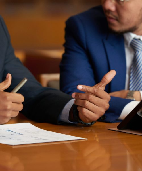 Cropped image of business people discussing financial report at meeting